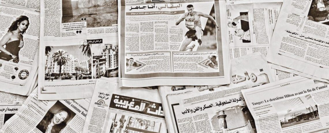 A flat lay of Arabic newspapers in Fès, Morocco, showcasing diverse articles.